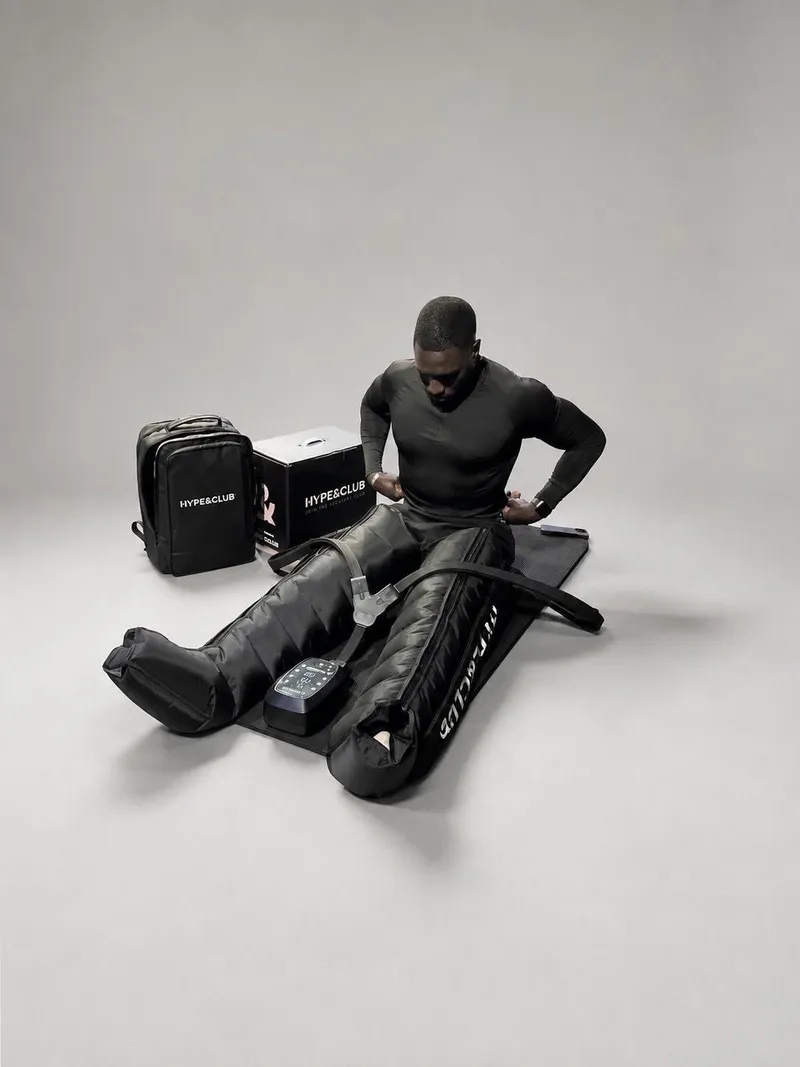Athlète enfilant les bottes HYPE&CLUB, sac et box à côté